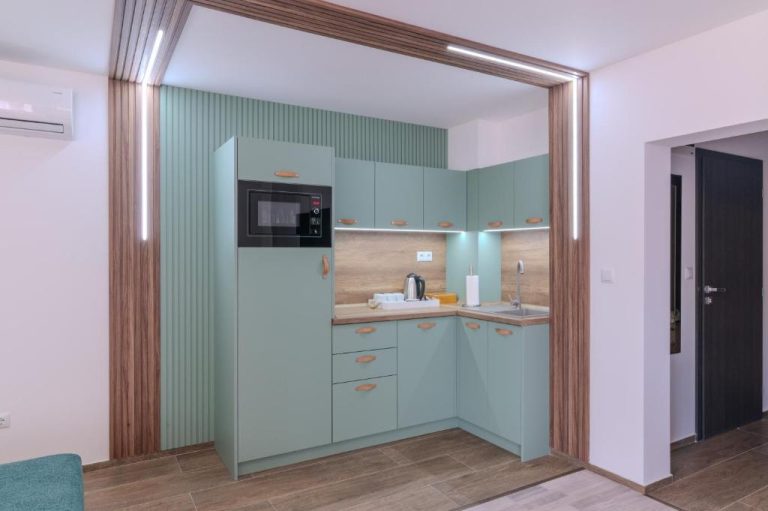 Cocina equipada con armarios verdes y microondas en Sea Twins Luxury Aparthotel a 150 m de la playa
