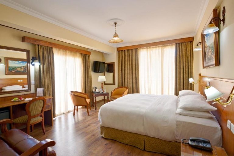 Habitación doble clásica con cama grande y suelo de madera en el Semeli Hotel