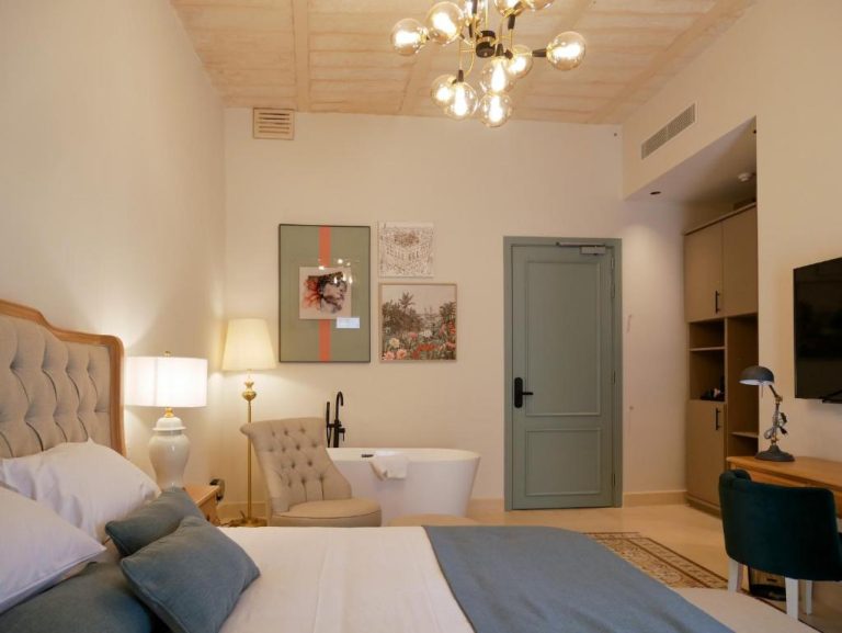 Habitación de lujo con bañera exenta y cama doble tapizada en el Hotel Battery House