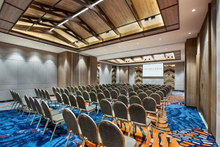 Amplio salón de conferencias con sillas y pantalla de proyección en el hotel Morazen Yogyakarta