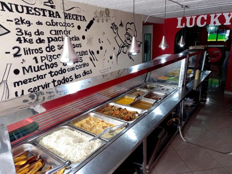 Buffet de comida caliente con arroz, guisos y plátanos fritos en el restaurante Lucky del Hotel San Pablo Boutique H9