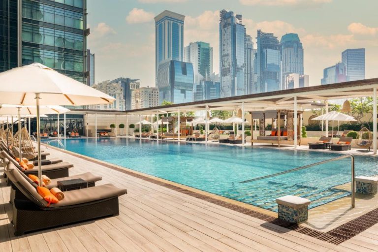 Piscina exterior con tumbonas y vistas al skyline del Marriott Marquis City Center Doha Hotel