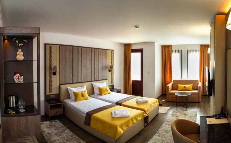 Habitación doble con camas amarillas y zona de estar en Spa Complex Aleksandar