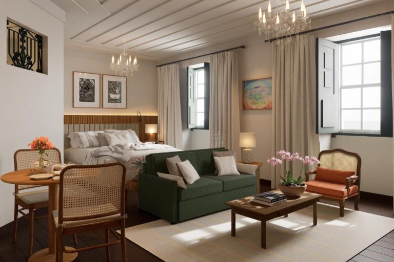 Suite con cama doble, sofá verde y zona de salón elegante en Hotel Villa Bahia