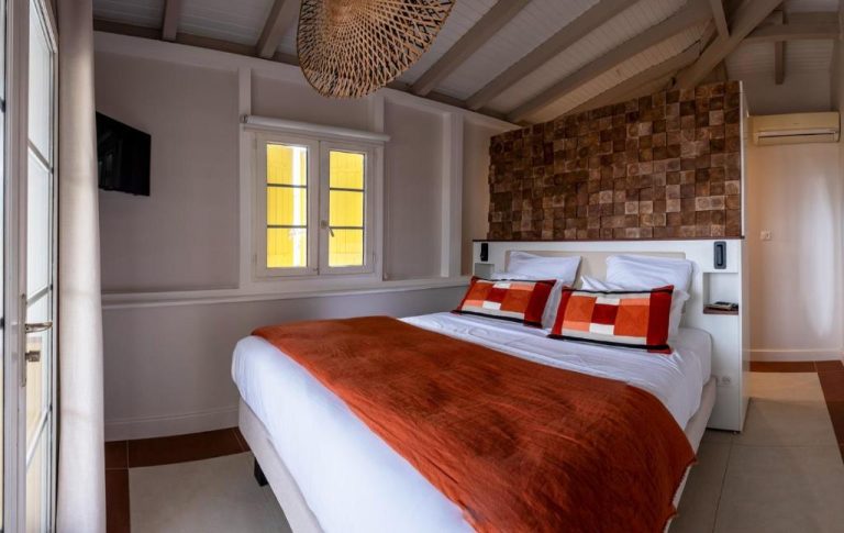 Habitación doble con cama king y pared de madera natural en La Suite Villa