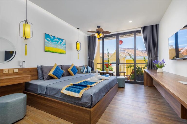 Habitación deluxe con cama king, decoración vietnamita y balcón con vistas en Hai Hội Villa Hoi An