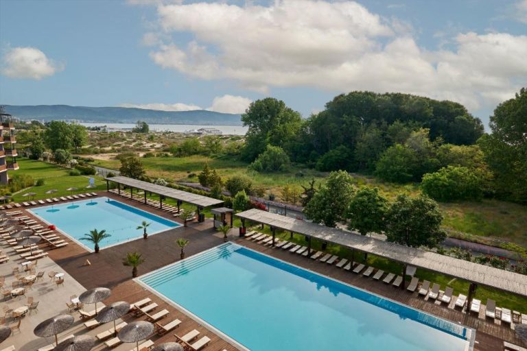 Dos piscinas exteriores con tumbonas del Sunny Beach Club Adults Only con vistas al mar
