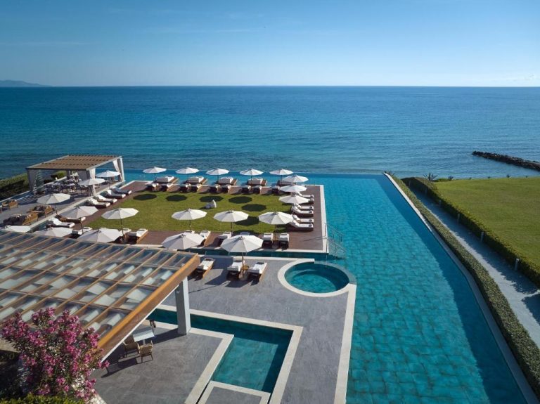 Piscina infinita con solarium y tumbonas frente al mar en Lesante Blu Adults Only Zakynthos