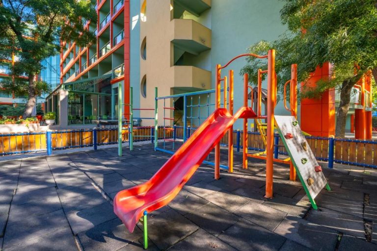 Zona de juegos infantil con tobogán rojo en el MPM Hotel Kalina Garden All Inclusive