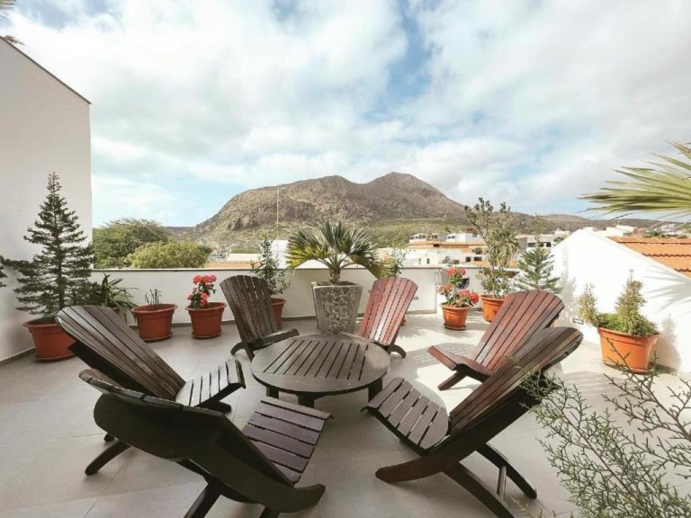 Terraza exterior con sillas de madera y plantas del Hotel Viajante con vistas a la montaña