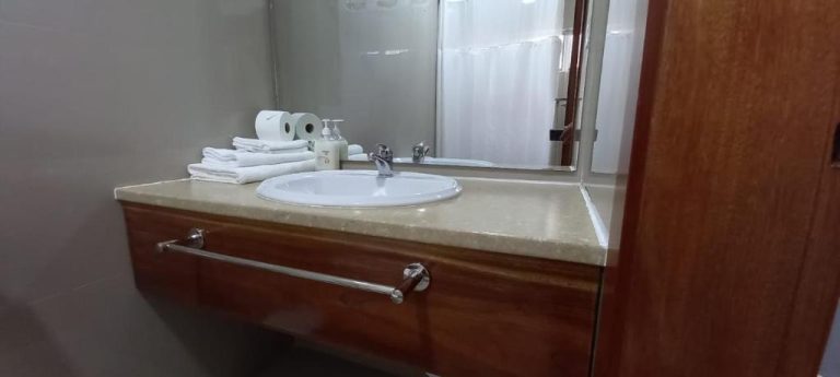 Baño del Hotel Viajante con lavabo empotrado, mueble de madera, toallas y amenities sobre encimera