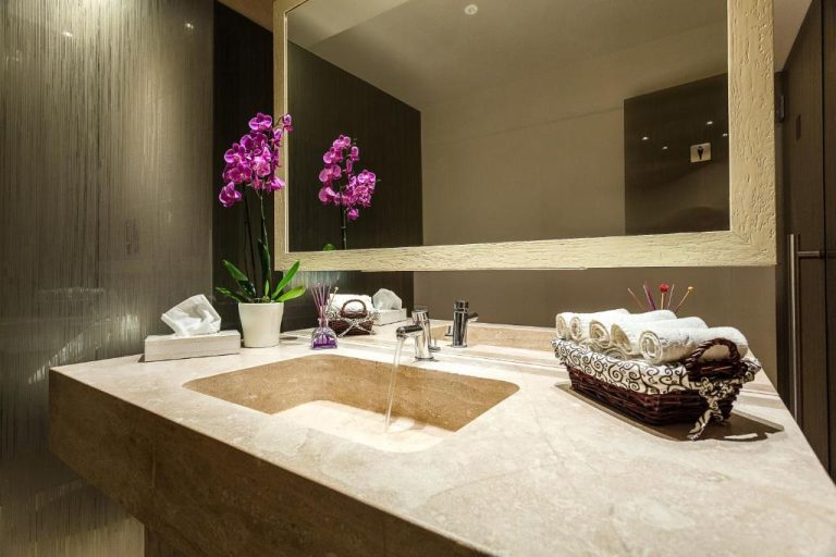 Baño de lujo con encimera de mármol y orquídeas en el Hotel Villa Margherita