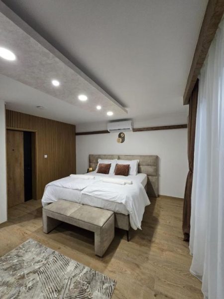 Habitación doble de lujo con cama king size y suelo de madera en Hotel Mažijanik
