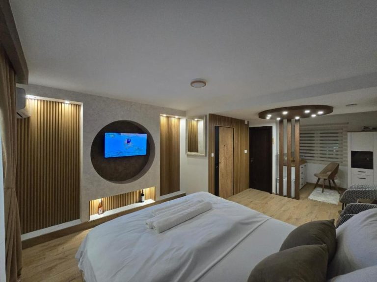 Habitación doble moderna con TV empotrada circular y decoración en madera del Hotel Mažijanik