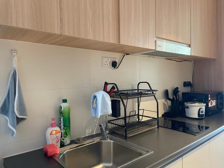 Cocina equipada con fregadero, vitrocerámica y arrocera en el apartamento Getawayhub Roxy Sematan Beach