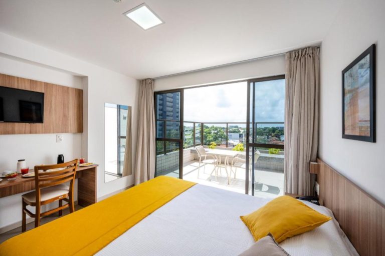 Habitación doble con cama y balcón con vista panorámica de la ciudad en Villa Park Hotel Recife