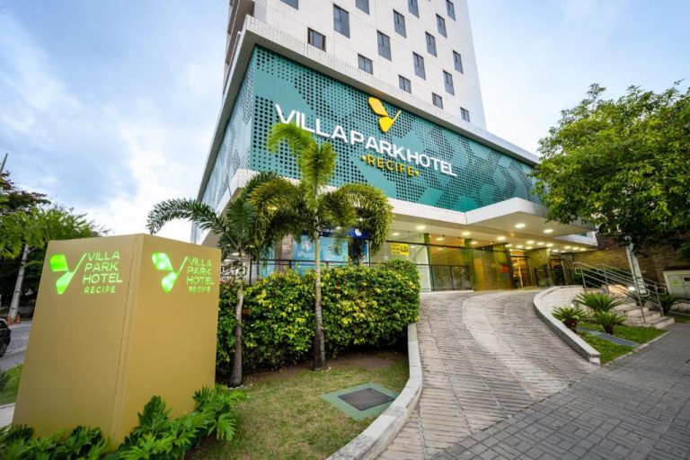 Fachada exterior del Villa Park Hotel Recife con jardines tropicales y entrada principal iluminada