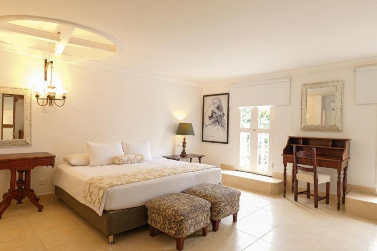 Habitación deluxe con cama doble, escritorio de madera y decoración colonial en Hotel Kartaxa