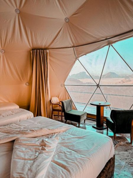 Interior de domo de lujo con camas y vista panorámica al desierto de Wadi Rum en Rum Lara Luxury Camp