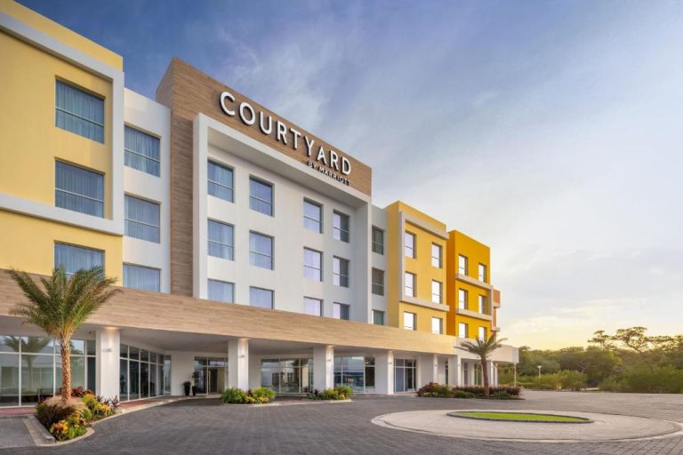 Fachada exterior del Courtyard by Marriott Curacao con entrada principal y palmeras tropicales