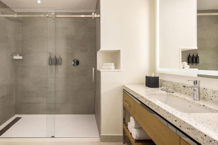 Baño moderno con ducha de cristal y encimera de terrazo en Courtyard by Marriott Curacao