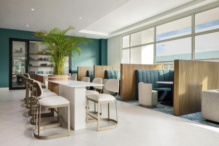 Zona lounge y área de trabajo del Courtyard by Marriott Curacao con cabinas privadas y decoración tropical