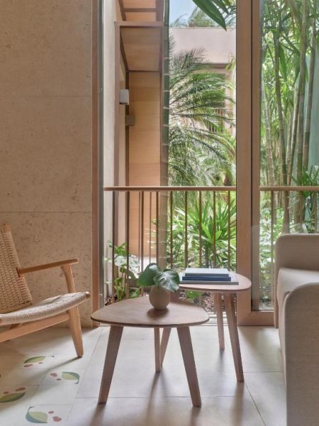 Sala de estar con balcón y vistas al jardín tropical en Kimpton Las Mercedes by IHG