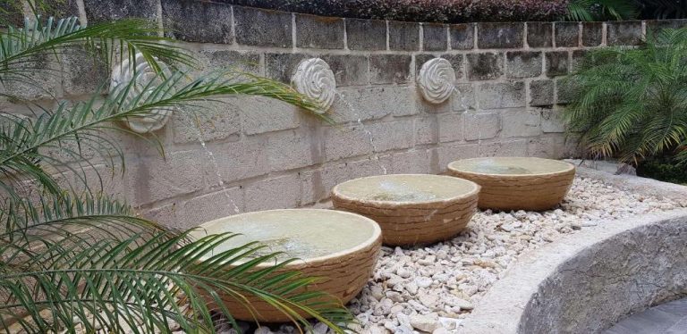 Fuente decorativa con cuencos de piedra y surtidores en el jardín del Radisson Aquatica Resort Barbados