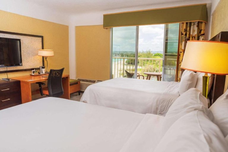 Habitación doble con dos camas y balcón con vistas a la piscina en Radisson Aquatica Resort Barbados