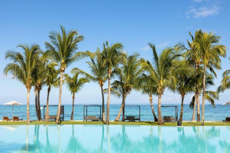 Piscina infinita con vistas al mar y palmeras tropicales en Dinarobin Beachcomber Golf Resort & Spa