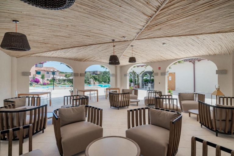Elegante terraza lounge con sillones de madera y techo de caña junto a la piscina del Hotel Sestante