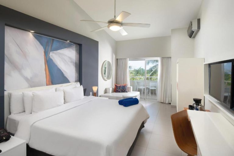 Habitación king size con balcón y vista tropical en Emotions by Hodelpa Juan Dolio, República Dominicana