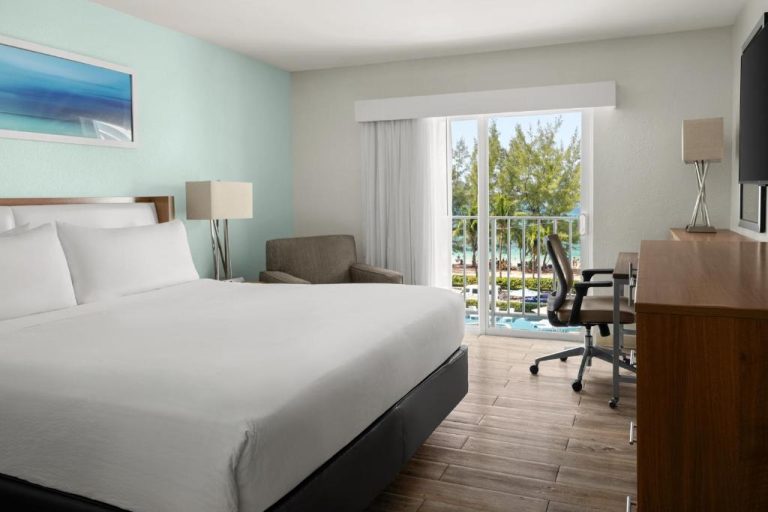 Habitación con cama king y balcón con vista a la piscina en Courtyard by Marriott Nassau Junkanoo Beach