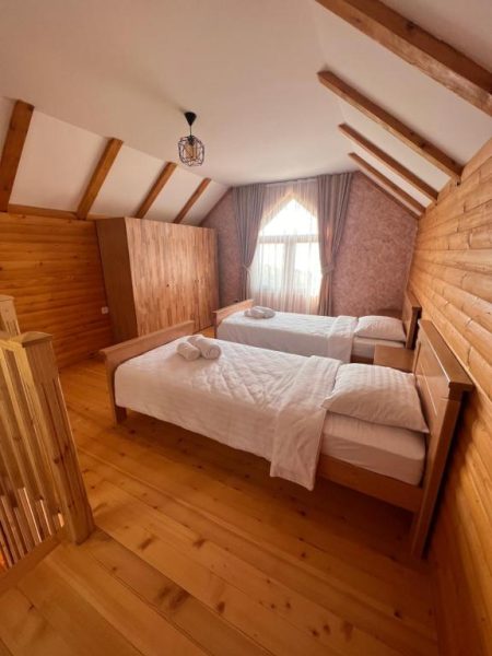 Habitación doble rústica con paredes de madera y suelo de tarima en Etno Selo Tačevine