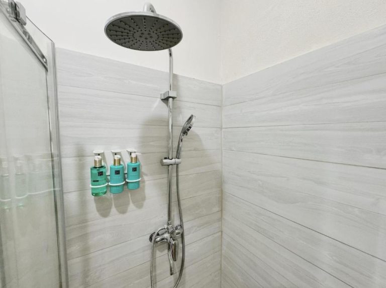 Ducha de lluvia con productos de baño en el baño del hotel Eden On the Sea