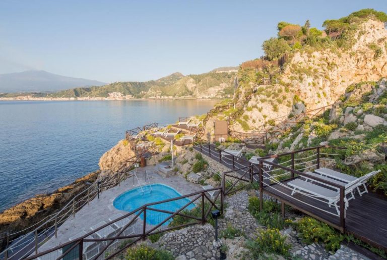 Piscina exterior con tumbonas y vistas al mar en UNA Hotels Capotaormina, Sicilia