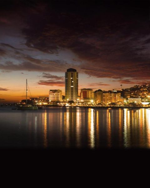 Vista nocturna del Simon Hotel frente a la bahía de Fort-de-France con reflejos de luces en el mar