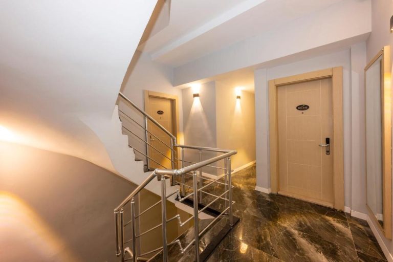 Pasillo y escaleras interiores con puertas de habitaciones iluminadas en Legend Tulip Hotel