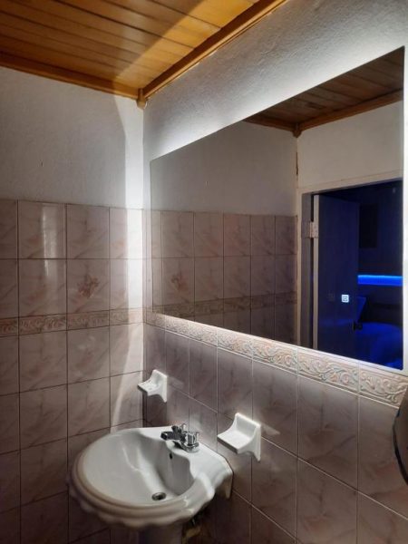 Baño con lavabo empotrado y espejo con iluminación LED del Big Apple Hotel