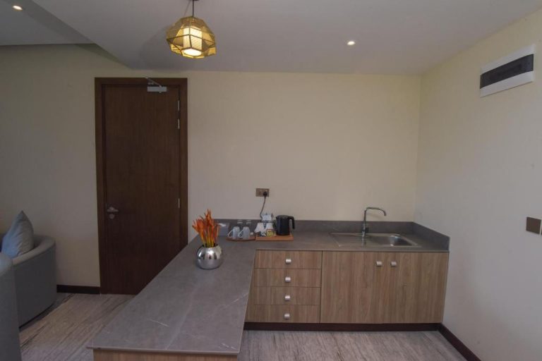 Kitchenette moderna con encimera de mármol y fregadero en suite del Golden Tulip Zanzibar Airport Hotel & Spa