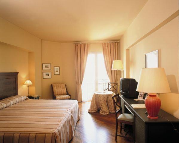 Habitación doble clásica con cama matrimonial y escritorio de madera en Grand Hotel Baia Verde