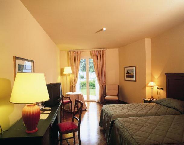 Habitación doble clásica con cama grande y terraza jardín en el Grand Hotel Baia Verde