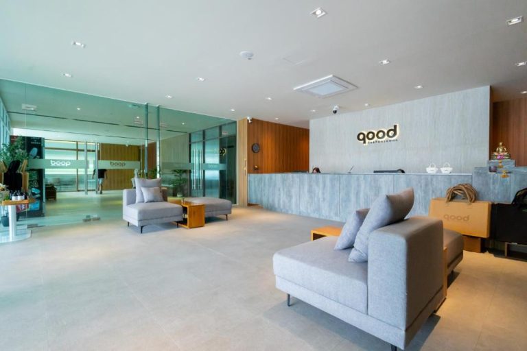 Recepción y lobby moderno con sofás grises del GOOD Nakhonsawan Hotel en Tailandia