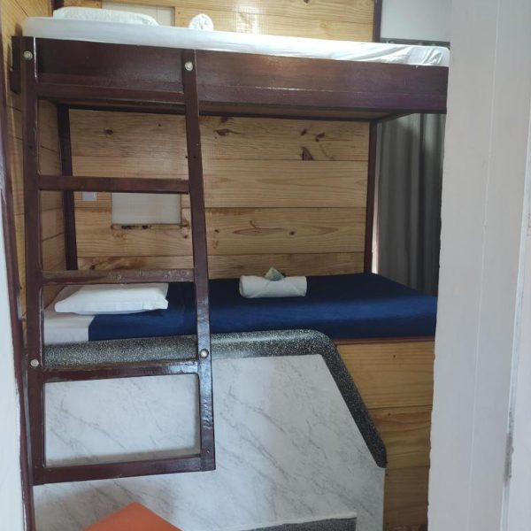Habitación con litera de madera y colchón azul en Hostel e Pousada Boa Vista