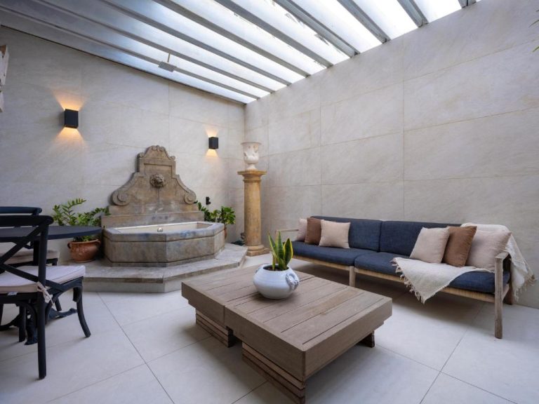 Patio interior con fuente clásica de piedra y zona lounge del O:Live Boutique Hotel en Sevilla