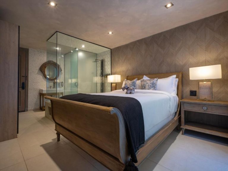Habitación deluxe con cama de madera y baño de cristal integrado en O:Live Boutique Hotel