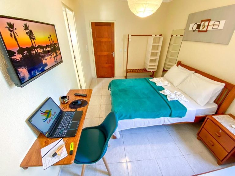 Habitación doble con escritorio, laptop y TV en Refúgio Pousada Fortaleza