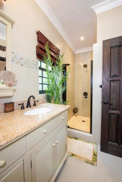 Baño elegante con ducha de mosaico y lavabo de granito en The Pilot House