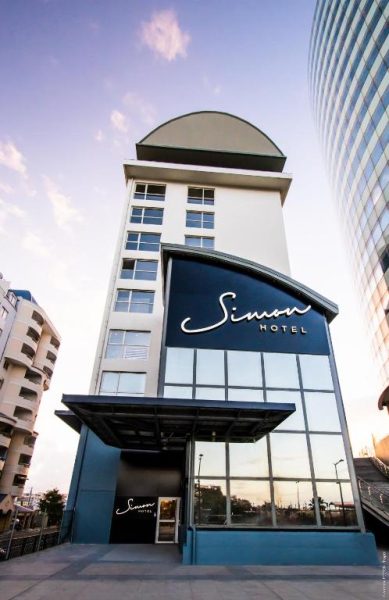 Fachada exterior del Simon Hotel con su distintivo letrero y arquitectura moderna de varios pisos