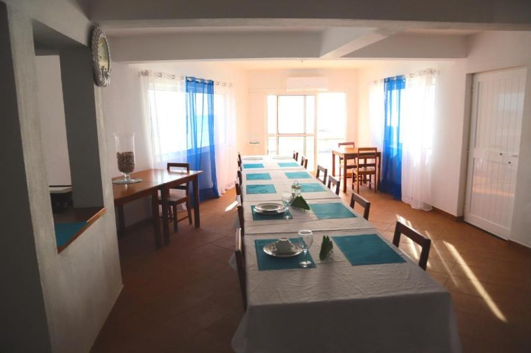 Comedor amplio con mesas decoradas en azul y blanco en Cacimba Sunset Lodge con luz natural